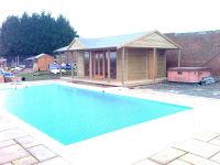 Pavilion used for swimming pool changing room with full length glass doors and windows. Additional gable to front of roof