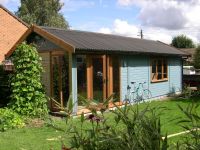 28 x 12 Orchard Room wih contemporary garden office double doors and sidelights. Matching window on front and black onduline roof. Painted by customer. 