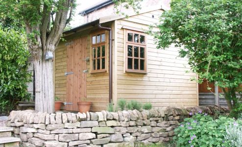 A sturdy Warwick Buildings Garden Storage Building fitting neatly into the available space. Customer choice here includes Georgian Style Windows.